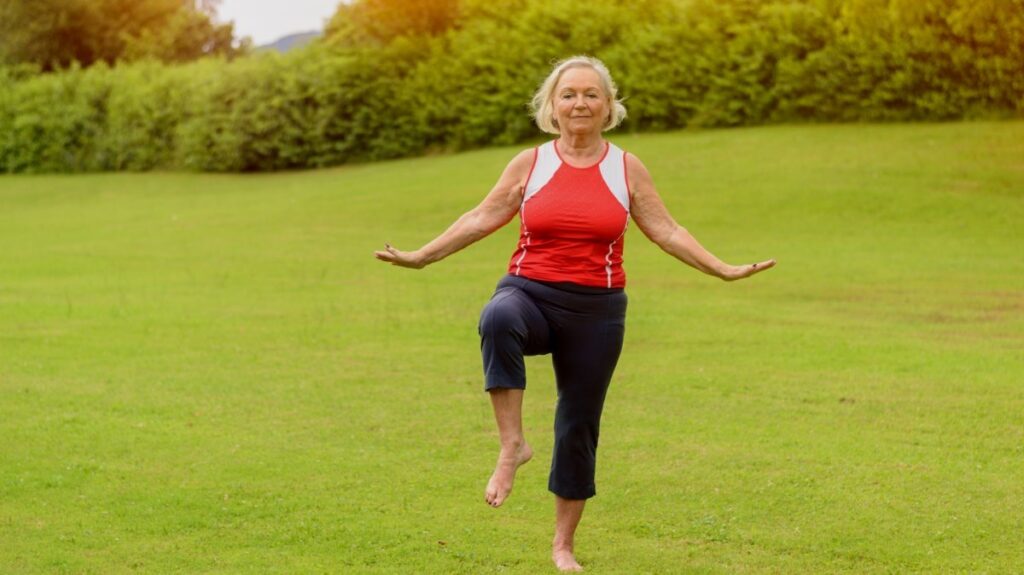 oudere vrouw doet balans- en yoga-oefening in park
