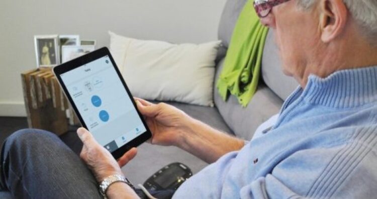oudere man gebruikt tablet zittend op bank in huis