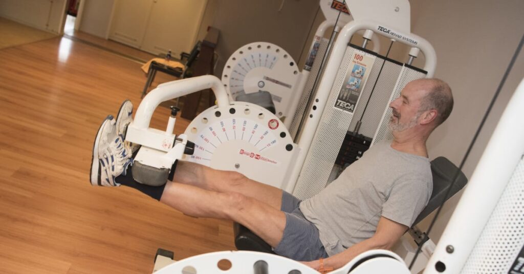 man traint op roeimachine in sportschool