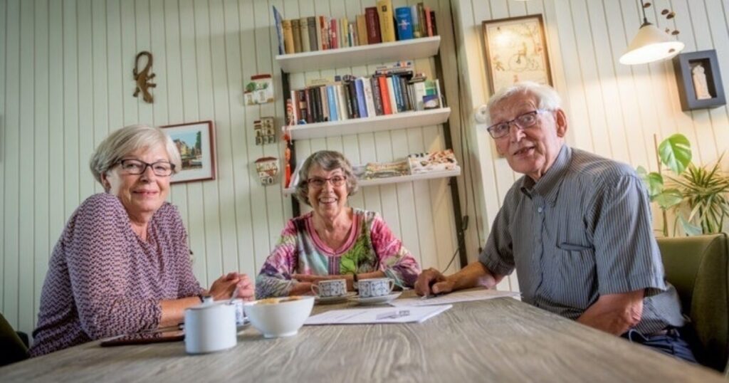senioren samen aan tafel in woonkamer