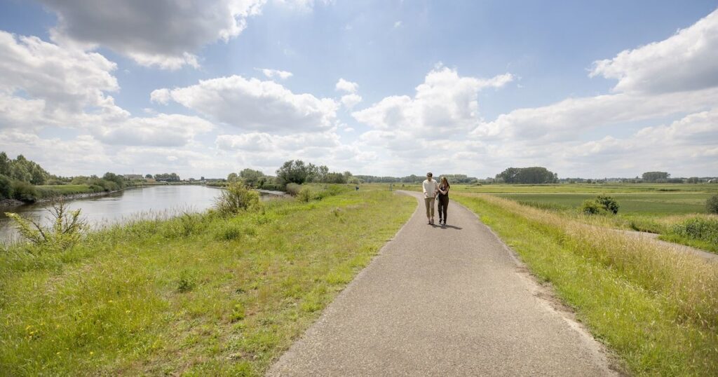 wandelaars langs rivier in groen landschap