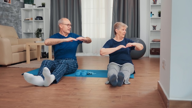 senioren doen rustige yoga oefeningen thuis